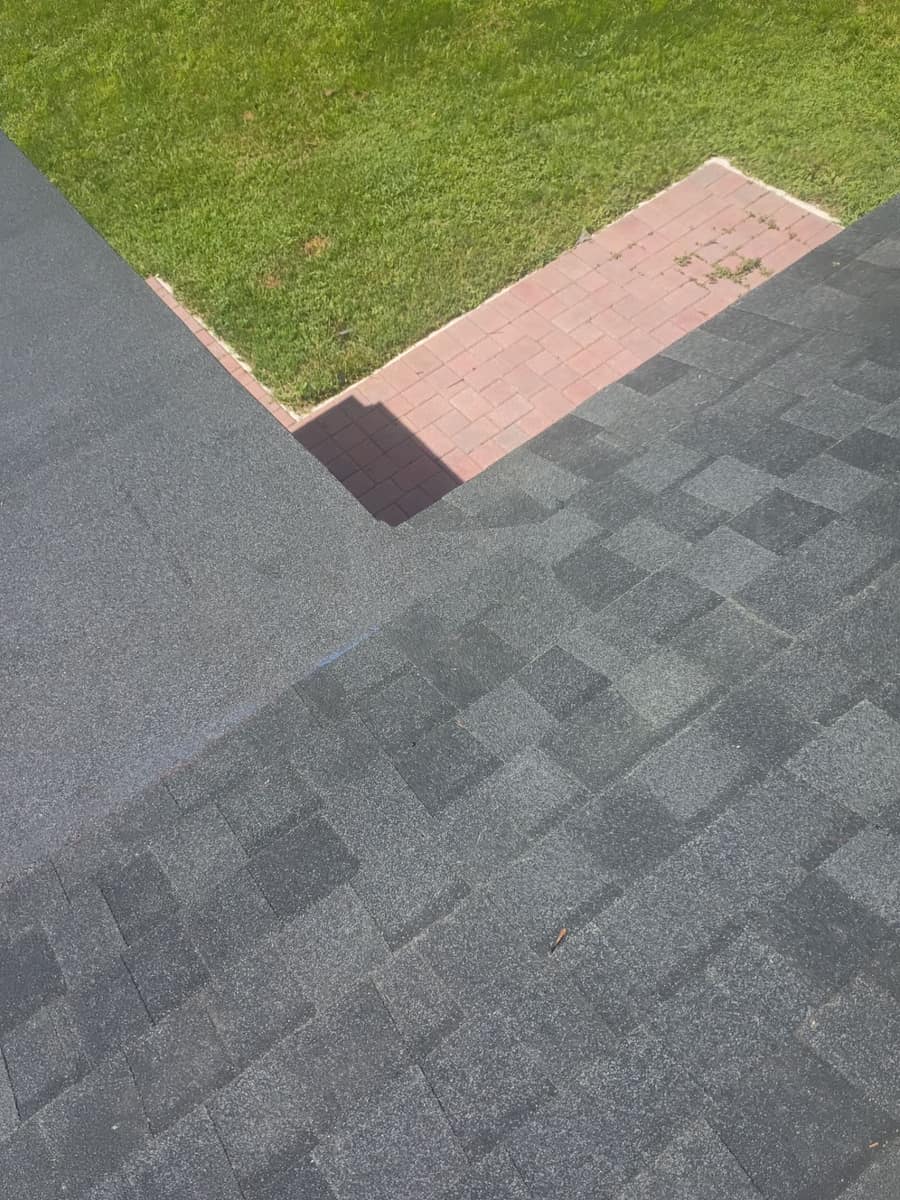 Shingled slope meeting a smooth low-slope section above a red brick paver patio