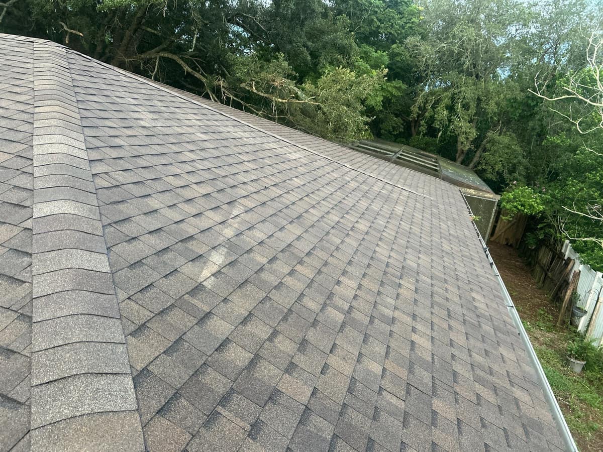 Long back slope of a new TAMKO Titan XT roof in Deltona, hip caps along the left