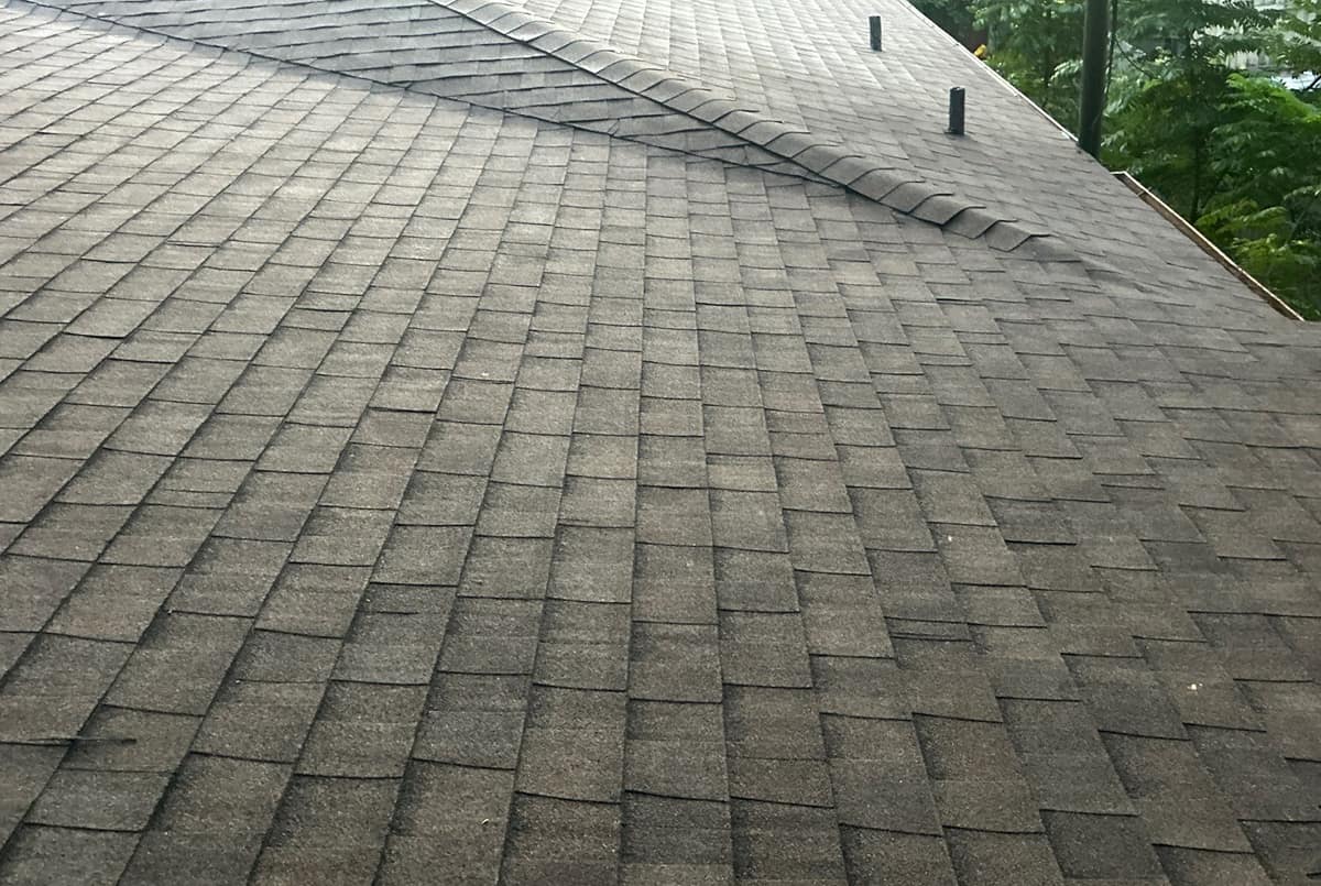 Hip caps lapped down a diagonal hip line, two black pipe vents on the slope above