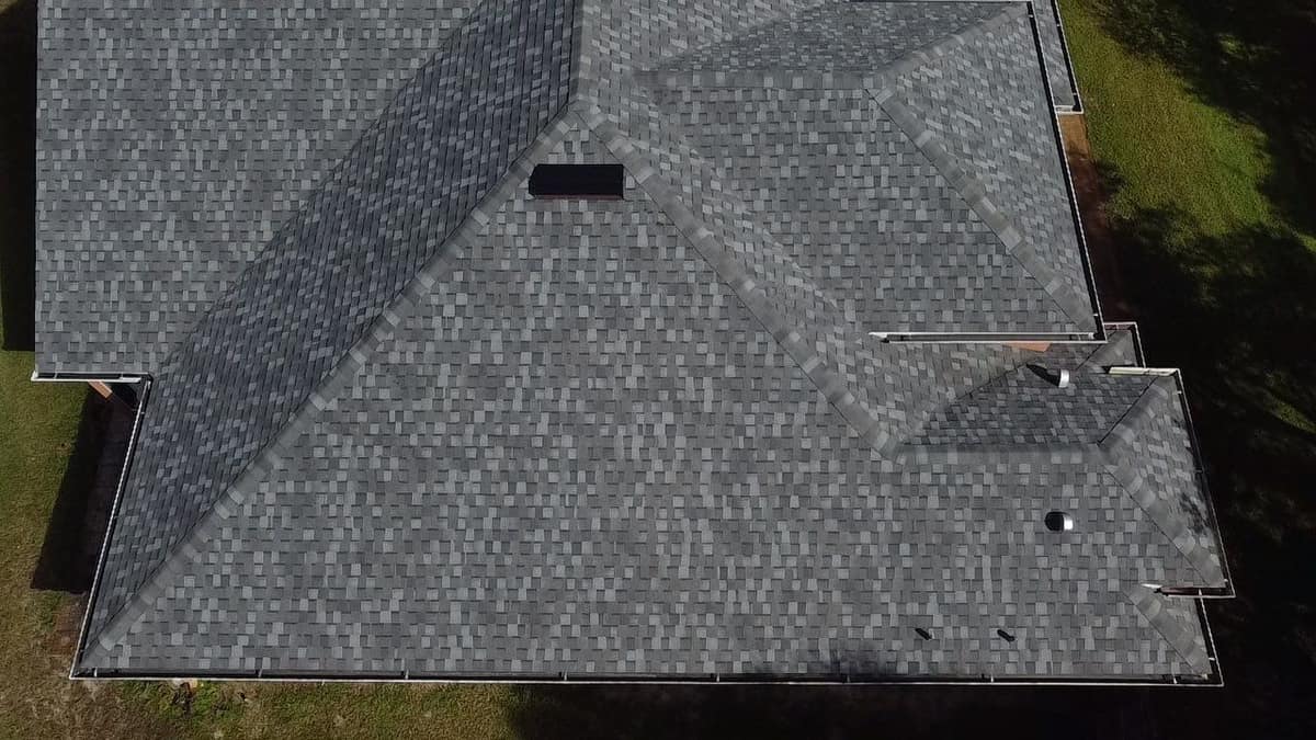 Drone view of capped hips, a box vent and a round pipe vent on the Eustis roof
