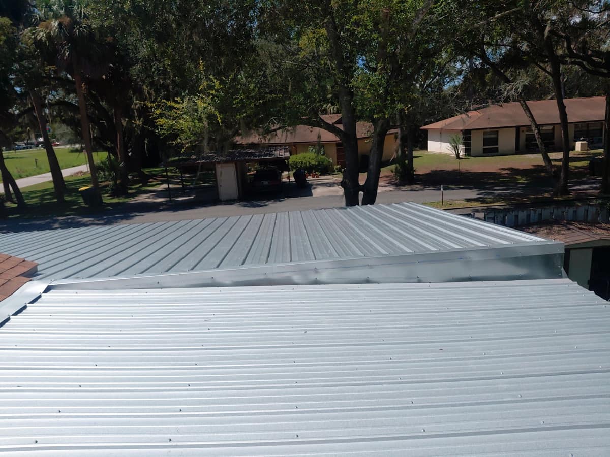 Two ribbed metal sections at different heights joined by a bent metal transition piece
