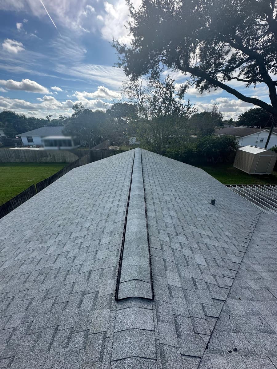 Ridge vent and capped ridge on the new light gray shingle roof of a Melbourne, FL home