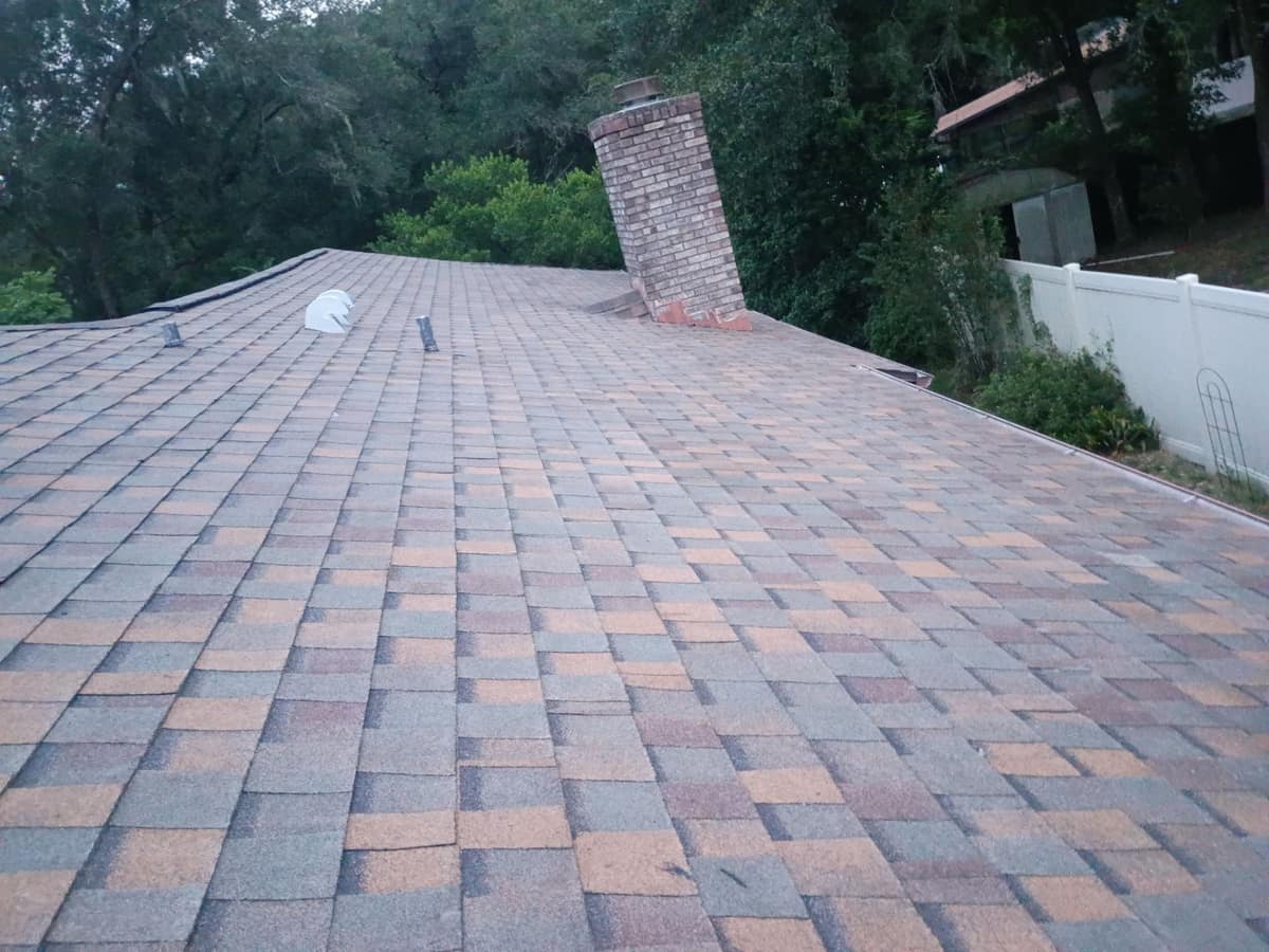 Side slope running up to the old brick chimney, a white exhaust vent nearby
