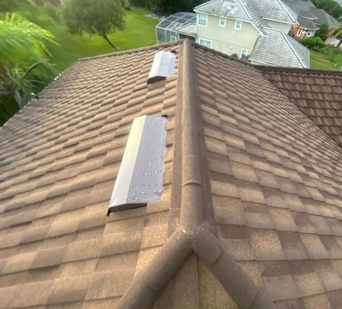 Two hip lines joining below a pair of long roof vents still beaded with rain