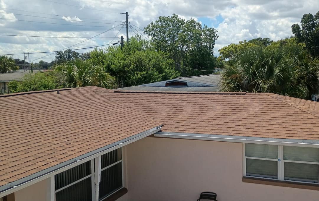 Back courtyard of an Orlando stucco home under a new sandy tan shingle roof and white gutters