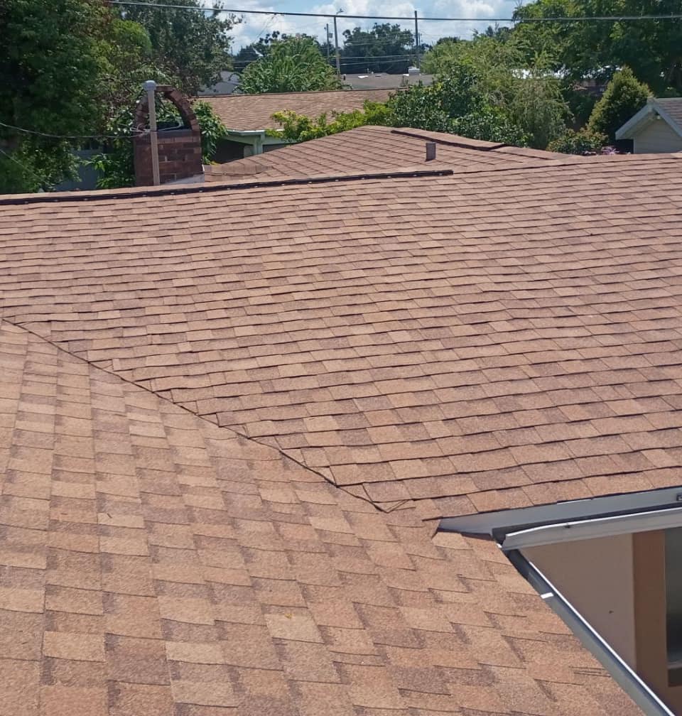 Wide tan slope meeting a hip line, with the arched brick chimney past the ridge