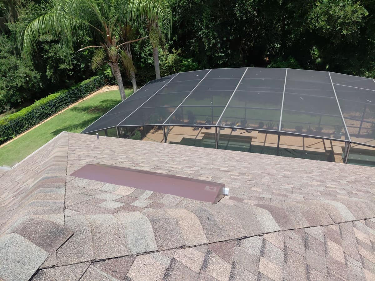 Long tinted skylight on the back slope above the screened pool enclosure in Palm Coast