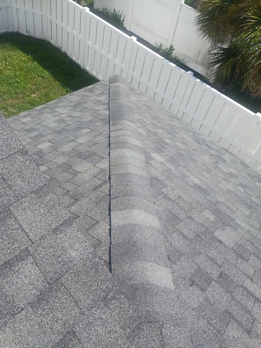 Hip caps stepping down to the back corner of the roof above a white privacy fence