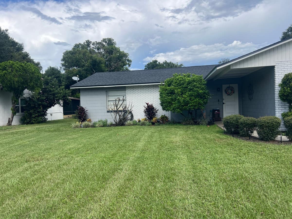 Winter Park home with gray painted block, white brick and a new charcoal shingle roof