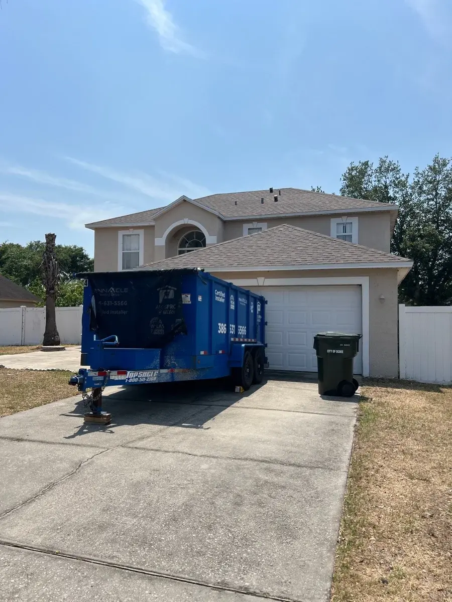 Pinnacle Roofing Group dump trailer at a residential roofing site
